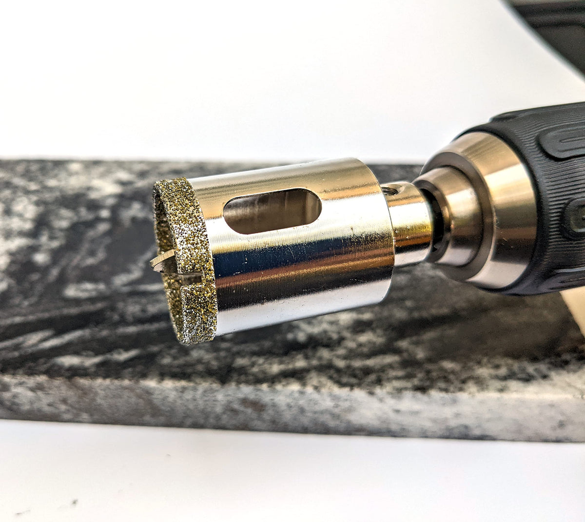 1-3/8 inch diamond hole saw on a cordless drill cutting a granite slab