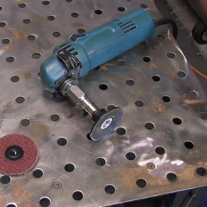 Angle grinder with flapper adapter and surface conditioning disc on a steel table